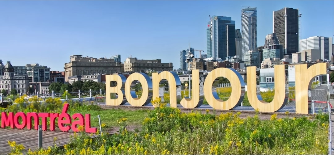 Enseigne « Bonjour Montréal » devant les gratte-ciel du centre-ville